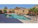 Backyard view of a private pool with a waterfall feature, surrounded by desert landscaping and a block wall at 12814 W Windrose Dr, El Mirage, AZ 85335