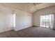 Bedroom featuring neutral carpet, a ceiling fan, a side window, and a glass sliding door at 1331 W Baseline Rd # 340, Mesa, AZ 85202