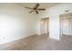 A spacious bedroom with plush carpet, a ceiling fan, and access to closet and bathroom at 1331 W Baseline Rd # 340, Mesa, AZ 85202