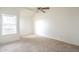 A bright bedroom features neutral carpet, a ceiling fan, and a window with natural light at 1331 W Baseline Rd # 340, Mesa, AZ 85202