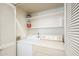 A tidy laundry room equipped with a washer, dryer, and shelving for storage, behind a louvered door at 1331 W Baseline Rd # 340, Mesa, AZ 85202