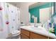 Well-lit bathroom showcasing a sink vanity, a shower with a paw print curtain, and a toilet at 13321 N 124Th Ave, El Mirage, AZ 85335