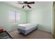 Neutral bedroom with light green walls, a ceiling fan, and a cozy twin bed by the window at 13321 N 124Th Ave, El Mirage, AZ 85335