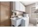 Functional laundry room with storage cabinets, a sink, and a washer-dryer set at 13321 N 124Th Ave, El Mirage, AZ 85335