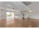 Open-concept living area with tiled and hardwood flooring with views to the pool and kitchen at 14426 N 52Nd Ave, Glendale, AZ 85306