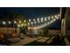 Nighttime backyard featuring a patio with string lights, a dining area, and a relaxing fire pit at 1446 E Canary Dr, Gilbert, AZ 85297