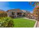 Green backyard featuring artificial grass, patio and outdoor seating, and a well-maintained exterior at 1446 E Canary Dr, Gilbert, AZ 85297