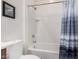 This bathroom features a tub and shower with white tile surround and a blue striped shower curtain at 1446 E Canary Dr, Gilbert, AZ 85297