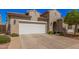 Attractive home exterior features an attached garage, desert landscaping, and a well-maintained facade at 1446 E Canary Dr, Gilbert, AZ 85297