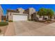 Home with a two-car garage and a well-maintained desert landscaping at 1446 E Canary Dr, Gilbert, AZ 85297