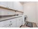 Bright laundry room features white cabinets, a sink and a washer and dryer at 1446 E Canary Dr, Gilbert, AZ 85297