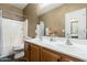 Bathroom featuring double sinks, an enclosed toilet and shower, and a large mirror at 14837 W Crocus Dr, Surprise, AZ 85379