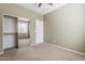 This bedroom has neutral carpet and paint, a door to a closet, and a single window at 14837 W Crocus Dr, Surprise, AZ 85379