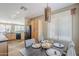 Open-concept dining room with wood cabinets, black appliances, and a dark wooden table with gray chairs and stylish decor at 14837 W Crocus Dr, Surprise, AZ 85379