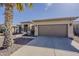 Well-maintained home featuring an attached two-car garage and desert landscaping at 14837 W Crocus Dr, Surprise, AZ 85379