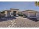 A tan single-story home with desert landscaping, stone accents, and a two-car garage at 14837 W Crocus Dr, Surprise, AZ 85379
