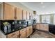 Kitchen featuring maple cabinets, black tile backsplash, and stainless steel appliances at 14837 W Crocus Dr, Surprise, AZ 85379