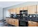 Kitchen featuring maple cabinets, black tile backsplash, and modern appliances at 14837 W Crocus Dr, Surprise, AZ 85379