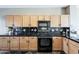 Kitchen featuring maple cabinets, black tile backsplash, and modern appliances at 14837 W Crocus Dr, Surprise, AZ 85379