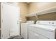 Functional laundry room featuring modern washer and dryer units and convenient shelving at 14837 W Crocus Dr, Surprise, AZ 85379