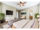 This cozy main bedroom features neutral tones, a ceiling fan, and a connecting door to the ensuite bathroom at 14837 W Crocus Dr, Surprise, AZ 85379