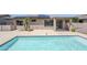 Stunning pool with an extended patio and lush surrounding landscape and solar panels at 14837 W Crocus Dr, Surprise, AZ 85379