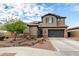 Two-story home featuring neutral stucco siding, a tile roof, dark garage door, and desert landscaping in the front yard at 1525 W Bent Tree Dr, Phoenix, AZ 85085