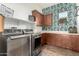 Laundry room featuring modern appliances, storage cabinets, and decorative wallpaper at 1525 W Bent Tree Dr, Phoenix, AZ 85085