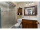 Bathroom features a glass-door shower, storage cabinet, and well-lit vanity at 15621 N Lakeforest Dr, Sun City, AZ 85351