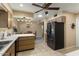 Bright kitchen with stainless steel fridge, tile flooring, and ceiling fan, connected to the dining area at 15621 N Lakeforest Dr, Sun City, AZ 85351