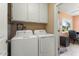 This laundry room provides convenience with a washer, dryer, and adjacent workspace bathed in natural light at 15621 N Lakeforest Dr, Sun City, AZ 85351