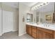 Bathroom with double sinks, wood cabinets, tile flooring, and a doorway leading to the bedroom at 16420 N Thompson Peak Pkwy # 1064, Scottsdale, AZ 85260