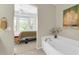 This bathroom features a soaking tub, and offers a glimpse into the serene bedroom at 16420 N Thompson Peak Pkwy # 1064, Scottsdale, AZ 85260