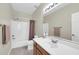 Bright bathroom features a tub with shower, and a wood vanity topped with a white countertop and large mirror at 16420 N Thompson Peak Pkwy # 1064, Scottsdale, AZ 85260