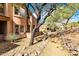 Landscaped hillside with desert foliage features a winding pathway leading towards well-maintained condominiums at 16420 N Thompson Peak Pkwy # 1064, Scottsdale, AZ 85260