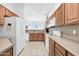 Well-lit kitchen features oak cabinetry, neutral counters and backsplash, white appliances, and eat-in dining space at 16420 N Thompson Peak Pkwy # 1064, Scottsdale, AZ 85260