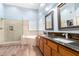 Primary bathroom featuring a soaking tub, glass shower, and double sink vanity with brown granite countertops at 17203 E Starflower Ct, Queen Creek, AZ 85142