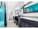 Bathroom featuring dual sinks with dark cabinets, and teal colored accent paint at 17203 E Starflower Ct, Queen Creek, AZ 85142