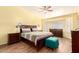 Cozy bedroom with a large bed, wood flooring, and natural light from the windows at 17203 E Starflower Ct, Queen Creek, AZ 85142