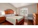 Cozy bedroom with wood floors, a large window, and neutral paint, creating a calm and inviting atmosphere at 17203 E Starflower Ct, Queen Creek, AZ 85142