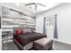 Bedroom with accent wall, wooden floors, and a window with curtains at 17203 E Starflower Ct, Queen Creek, AZ 85142