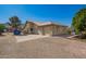 Tan single-story home with a three-car garage and a gravel driveway at 17203 E Starflower Ct, Queen Creek, AZ 85142