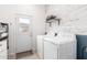 Bright laundry room featuring a washer and dryer, stylish white door, and modern decor on an accent wall at 17203 E Starflower Ct, Queen Creek, AZ 85142