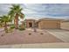 Charming single-story home featuring desert landscaping, mature palms, and a two-car garage at 17335 W Gould Mine Ln, Surprise, AZ 85387