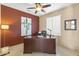 Comfortable home office features tile floors, ceiling fan, and wooden desk at 17335 W Gould Mine Ln, Surprise, AZ 85387