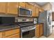 Kitchen featuring stainless appliances, tile countertops and wooden cabinetry at 17335 W Gould Mine Ln, Surprise, AZ 85387