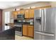 Well-lit kitchen boasts stainless appliances and plenty of wood cabinetry at 17335 W Gould Mine Ln, Surprise, AZ 85387