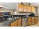 Kitchen featuring stainless dishwasher, oak cabinets, and granite counters at 17335 W Gould Mine Ln, Surprise, AZ 85387