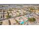 Wide aerial view of a community featuring houses, many with solar panels, complemented by a sparkling pool at 17423 W Yavapai St, Goodyear, AZ 85338