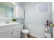 Bathroom with white vanity, wall cabinet, toilet, and light blue walls at 17423 W Yavapai St, Goodyear, AZ 85338